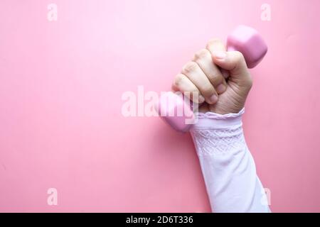 top view of woman hand holding pink dumbbell. Stock Photo