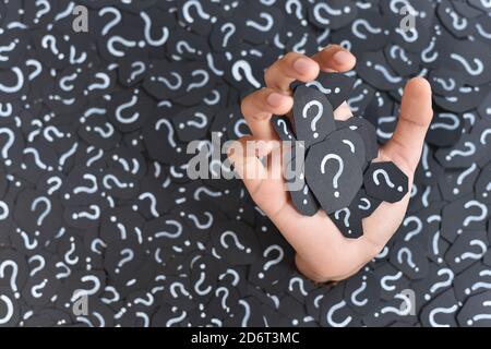 hand submerged from pile of paper with question mark, Concept of q&a,questions and answer Stock Photo