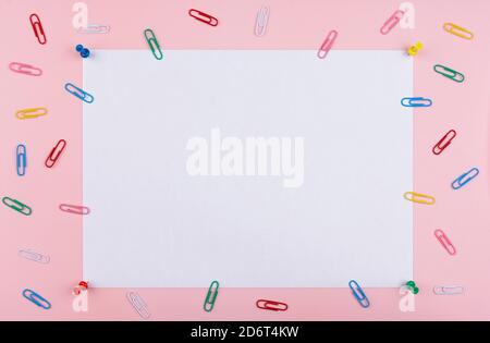 white sheet fastened with clerical multi-colored buttons on a pink background. Stock Photo