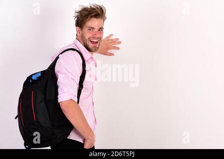 Young man backpacker walking in studio isolated on white background. Guy with rucksack and happy face. Stock Photo