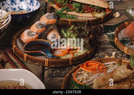 Appetizing Vietnamese spring rolls with shrimps served on table with various Asian food in traditional restaurant Stock Photo