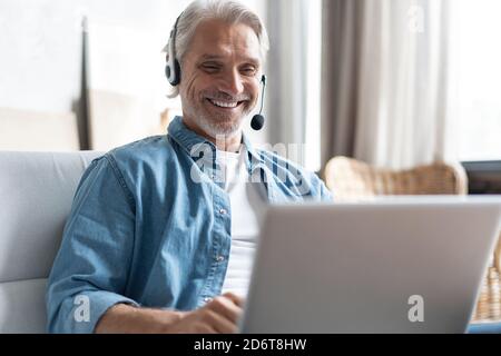 Smiling male call center agent or telemarketer work consult client online, good customer service concept Stock Photo