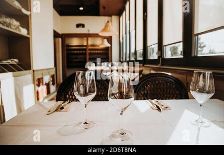 Crystal transparent goblets placed on table setting with tableware in cozy restaurant in Madrid Stock Photo