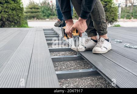 Man assembling composite deck using cordless screwdriver. Stock Photo