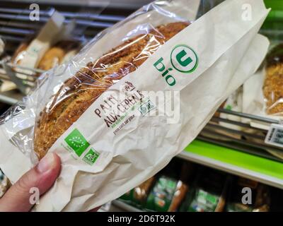 Puilboreau, France - October 14, 2020:Man buying organic cereal bread in the bakery section of a supermarket Stock Photo