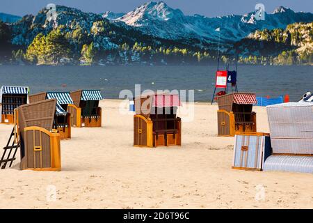 Bungalows sun protection on the beach for rent in summer holiday and snowy mountains in the background Stock Photo