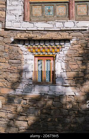 Exterior of aged stone house with weathered small window in Sichuan province of China. Tibetan village near to Maerkang, called Barkam in Tibetan. It Stock Photo