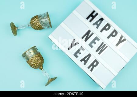 Happy new year light box with goldenchampagne glasses on blue background Stock Photo