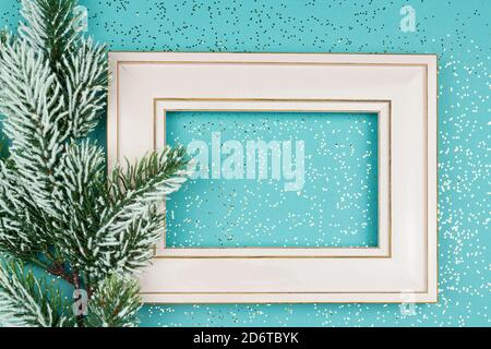 Festive greeting card for Christmas with photo frame, spruce tree branch on blue confetti background Stock Photo