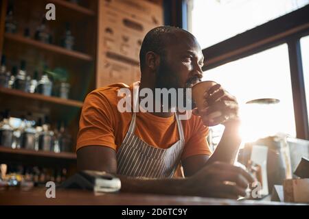 Handsome male bartender drinking coffee at work Stock Photo