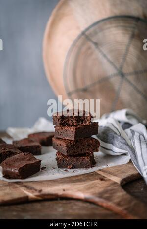 Yummy chocolate brownie pieces on cutting board on marble table at home Stock Photo