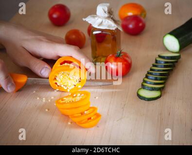 Vegetables peppers, tomatoes, zucchini on a cutting board and the hands of a chef Stock Photo