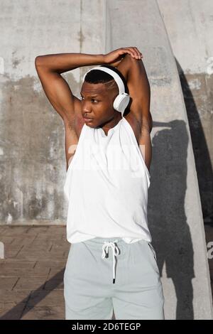 Confident African American runner warming up and doing stretching exercise while preparing for active training Stock Photo