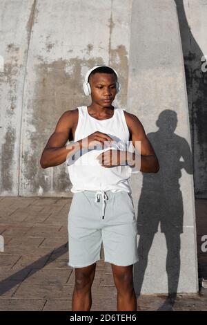 Confident African American runner warming up and doing stretching exercise while preparing for active training Stock Photo