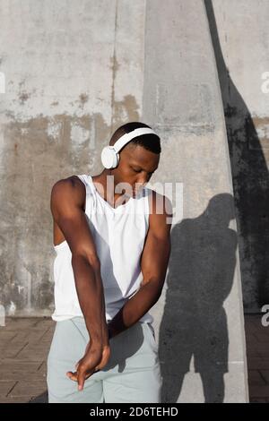 Confident African American runner warming up and doing stretching exercise while preparing for active training Stock Photo