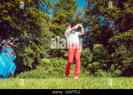 Golf player at the tee hitting ball far Stock Photo