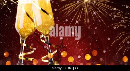 Two glasses of champagne with gold ribbons on red background Stock Photo