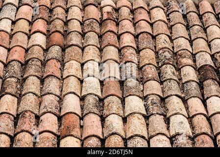 Closeup of weathered rusty red tiles on roof of medieval building for textured background Stock Photo