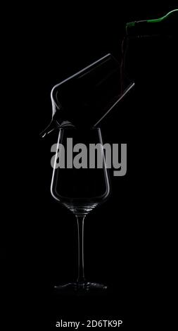 wine is poured into a glass silhouette on Black Background. One glass is broken. High quality photo Stock Photo