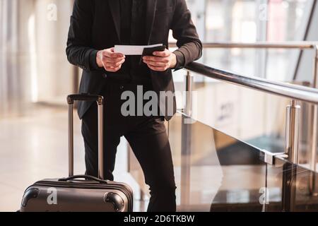 Man checking travel details in his boarding pass Stock Photo