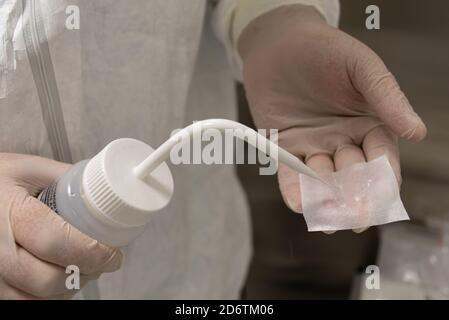 Doctor or nurse cleaning and disinfecting tools with gloves and disinfectant. Antibacterial agent in the hands, close up Stock Photo