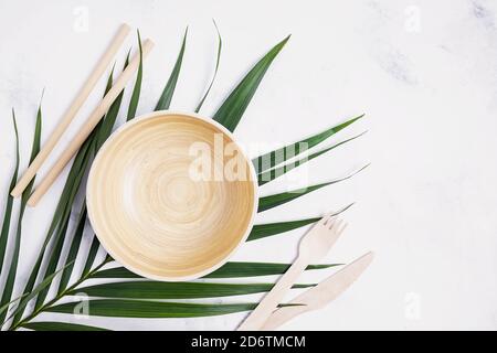 Eco friendly tableware. Bamboo bowl, drinking straws an wooden cutlery on marble table with copy space Stock Photo