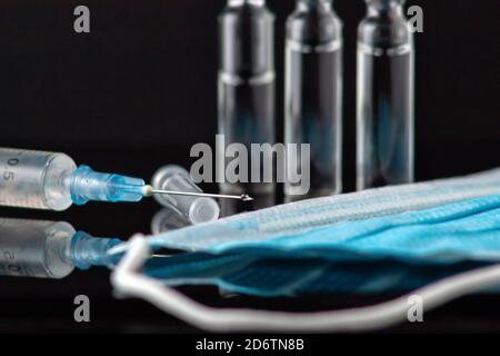 A row of ampoules with medicine on a black table. Horizontal composition. Foreground. Stock Photo