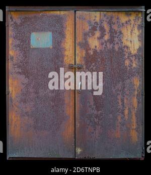 Two half gates of old curved sheets of rusty iron. Isolated on black Stock Photo