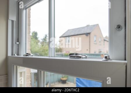 Detailed view of a newly installed, energy saving double glazed sash window looking to  small patio area. Stock Photo