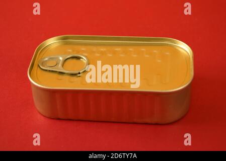 sealed food tin with ring pull isolated on a red background Stock Photo