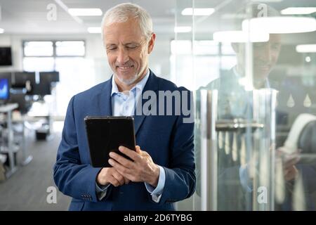 Senior businessman using digital tablet at modern office Stock Photo