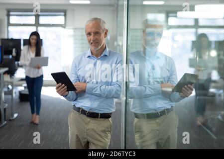 Portrait of senior businessman using digital tablet at modern office Stock Photo
