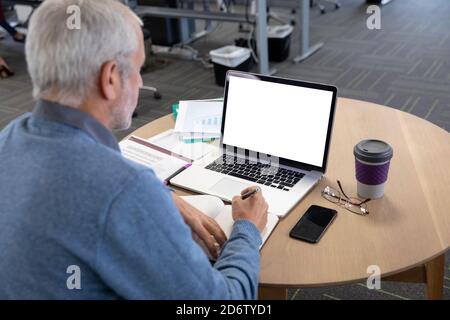 Senior businessman taking notes at modern office Stock Photo