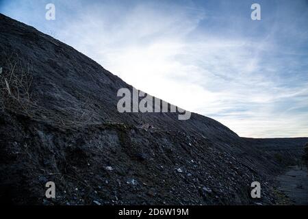 Landfill mountain with blue sky and blurred clouds Stock Photo