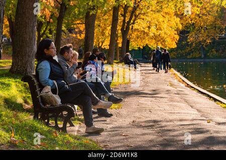 Montreal, CA - 19 October 2020: People enjoying a warm and sunny day at La Fontaine Park in the Autumn season Stock Photo