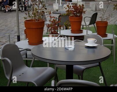 empty coffee cup and ashtray on a table in a secluded street cafe Stock Photo