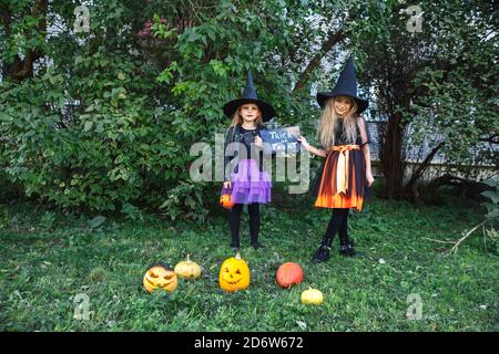 Halloween little girls in witch costume out for trick-or-treating Stock Photo