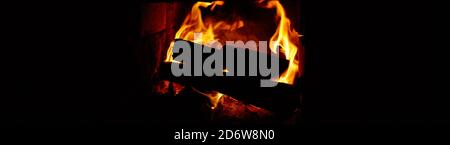 Crest of flame on burning wood in fireplace. Close-up of fire in hot stove. Banner or background, copy space Stock Photo