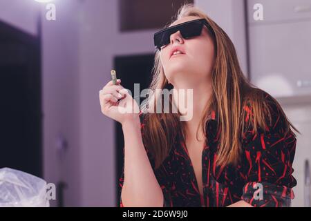 Swag girl sniffing cocaine imitation, flour . blonde Woman stoned. White background. Stock Photo