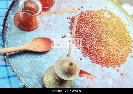 Coffee beans on a large old tray. Vintage Turk and wooden spoon in the cafe. Stock Photo