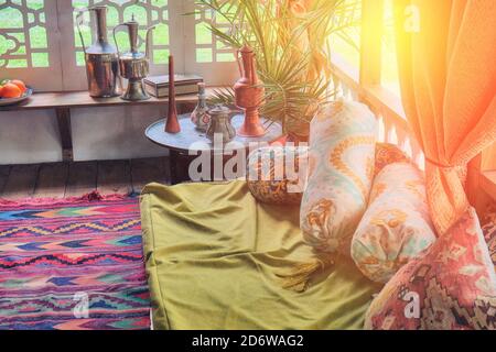 Interior of the mobile tent of the Ottoman Empire. Decoration of Turkish houses of the 18th or 19th century - hookah, carpets, Turk for coffee, fruit. Stock Photo