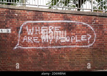 White painted graffiti on red brick wall Stock Photo