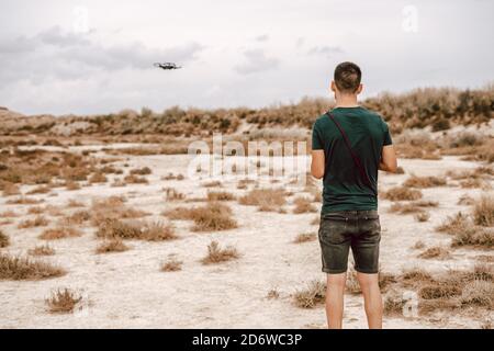 Young man piloting a drone on the Barcenas Reales desert in Navarra, Spain Stock Photo