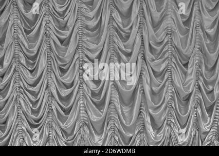 Natural texture of the curtains in a music hall. Real background of the veil on stage in the concert hall. Curtain of silver fabric. Stock Photo