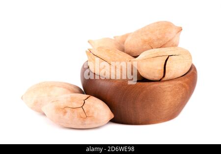 Pecan nuts in wooden bowl, isolated on white background. Unshelled pecan. Stock Photo