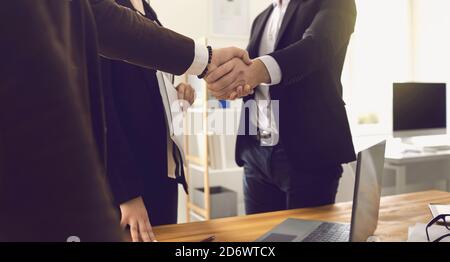 Businesspeople shaking hands in office confirming further productive cooperation Stock Photo