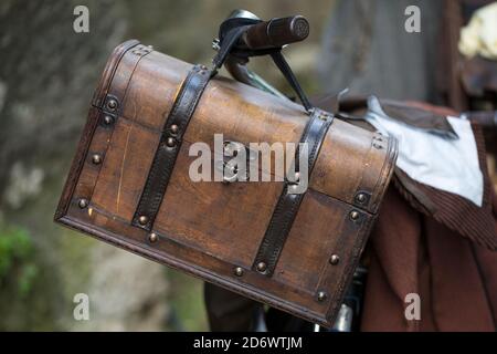 Old wooden chest hanging at the handlebar of a bicycle Stock Photo