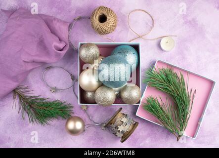 Table with Christmas decorations in a blue box, candles and pine branches. Stock Photo