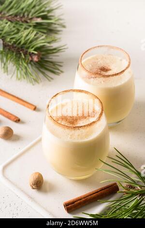 Two holiday Christmas eggnog with grated cinnamon and nutmeg on white. Close up. Stock Photo