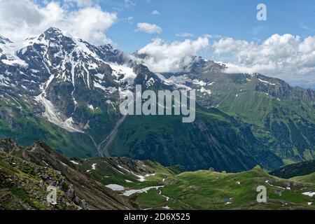 Landscape in the Alps, the highest mountains in Europe. Austria or Italy in autumn or spring, cloudy weather and rocks in cold windy day, greem meadow Stock Photo